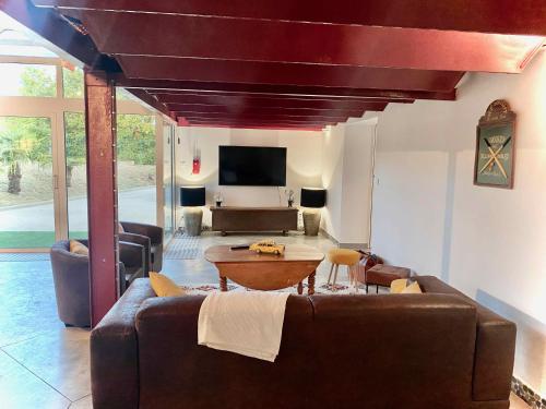 a living room with a couch and a table at L'atelier Insolite - Piscine chauffée in Montauban