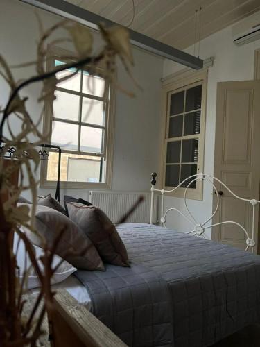a bedroom with a bed in a room with windows at The Old Town Heritage House Platform 357 in Nicosia