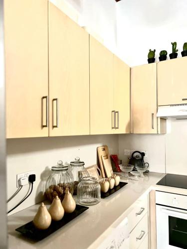a kitchen with white cabinets and vases on a counter at The Old Town Heritage House Platform 357 in Nicosia