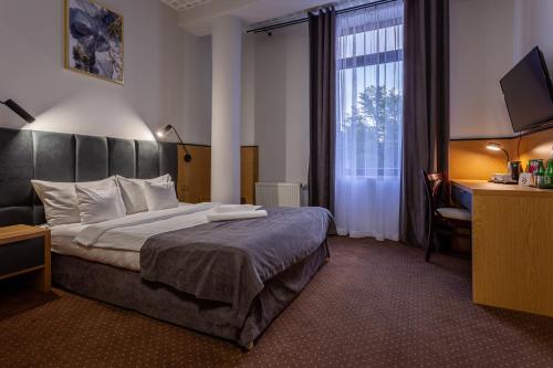 a hotel room with a bed and a window at Hotel Poniatowski in Radom
