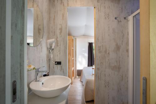 a bathroom with a white sink and a mirror at Camping Il Capannino Glamping Village in Marina di Bibbona