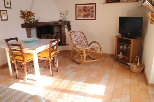 a living room with a table and chairs and a television at Casa Lella in Fabriano