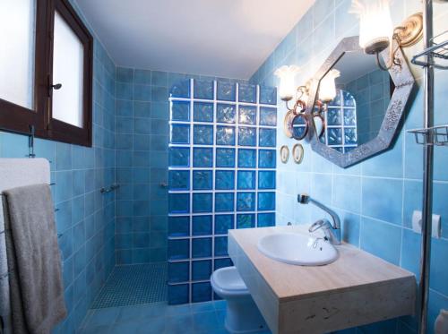 a blue bathroom with a sink and a mirror at Akrotiri in Santa Ponsa