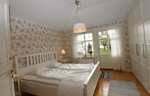 1 dormitorio con cama blanca y ventana en Unique house in Kopmannebro with fantastic lake plot, en Köpmannebro