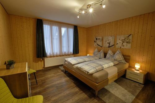 Schlafzimmer mit einem Bett, einem Schreibtisch und einem Fenster in der Unterkunft Ferienwohnung in Wasen