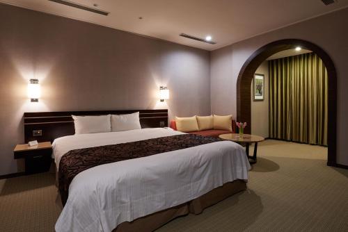 a hotel room with a large bed and a couch at SOL Hotel in Hsinchu City
