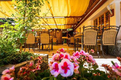 a patio with tables and chairs and flowers at Hotel Restaurant Les Lilas in Les Diablerets