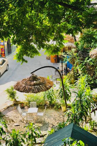 a table and chairs and an umbrella in a garden at Pao's Leisure Homestay in Ha Giang