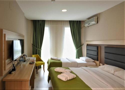 a hotel room with two beds and a television at Samsun Osmanlı Otel in Samsun