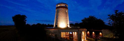 um edifício com um farol em cima à noite em The Windmill Blackthorn Hill em Bicester