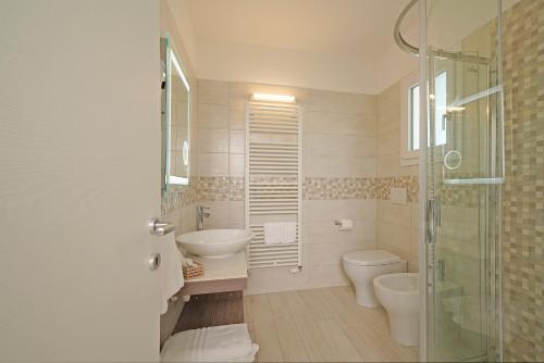 a bathroom with a sink and a toilet and a shower at Hotel Strand a frontemare in Lido di Jesolo