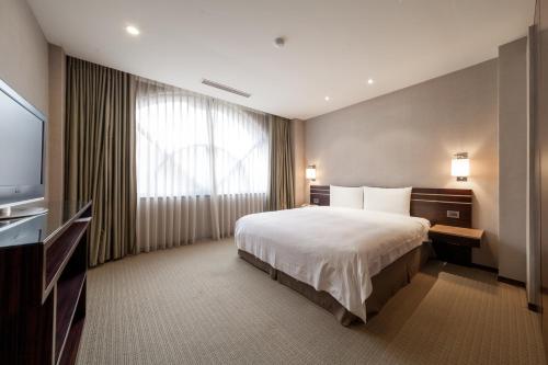 a hotel room with a bed and a television at SOL Hotel in Hsinchu City