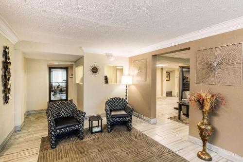 a lobby with two chairs and a vase with flowers at Quality Inn in Pensacola