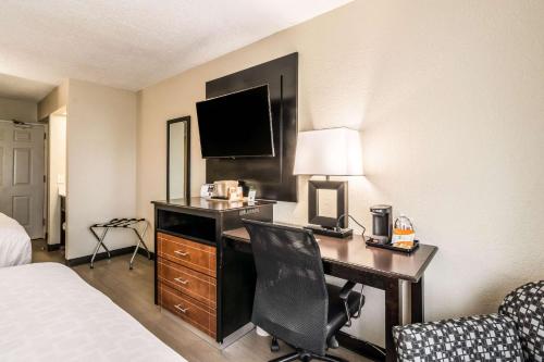 a hotel room with a desk with a computer and a bed at Quality Inn in Pensacola
