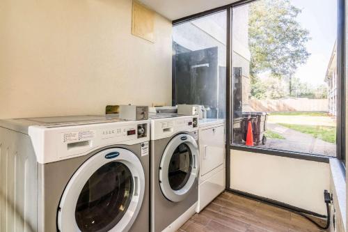 a laundry room with a washing machine and a window at Quality Inn in Pensacola
