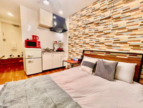 a bedroom with a large bed and a kitchen at tani house in Tokyo