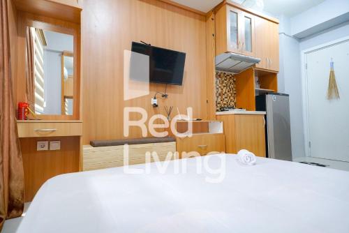 ジャカルタにあるRedLiving Apartemen at Jalan Pramuka - Aokla Propertyのベッド、テレビ、キッチンが備わる客室です。
