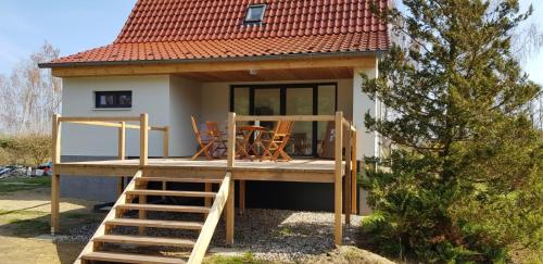 a tiny house with a porch and a deck at Mecklenburgische Seenplatte - Saniertes und gemütliches Ferienhaus mit großem Garten und Steg in Großzerlang