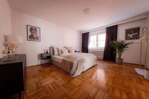 a bedroom with a bed and a wooden floor at Bonnystay Landshut Gallery im Zentrum in Landshut