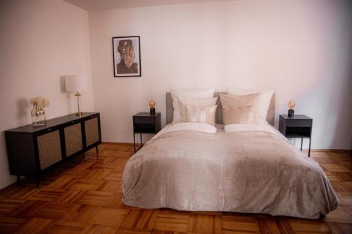 a bedroom with a large bed with two night stands at Bonnystay Landshut Gallery im Zentrum in Landshut