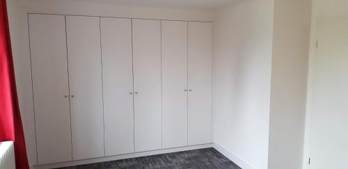 a white closet with white cabinets in a room at Mecklenburgische Seenplatte - Saniertes und gemütliches Ferienhaus mit großem Garten und Steg in Großzerlang