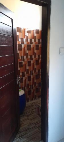 a bathroom with a toilet and a tile wall at Homestay Rafatar in Rantaupanjang
