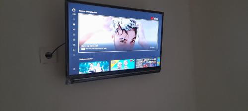 TV de pantalla plana colgada en la pared en Homestay Rafatar en Rantaupanjang