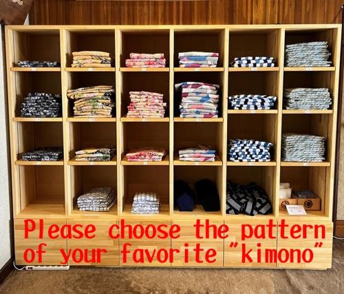 a wooden book shelf filled with shirts and ties at Shimaya in Yamanouchi