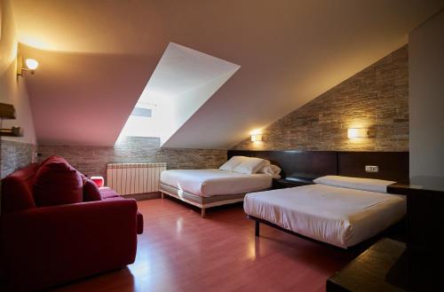 アビレスにあるHotel Villalegreのベッド2台とソファが備わるホテルルームです。
