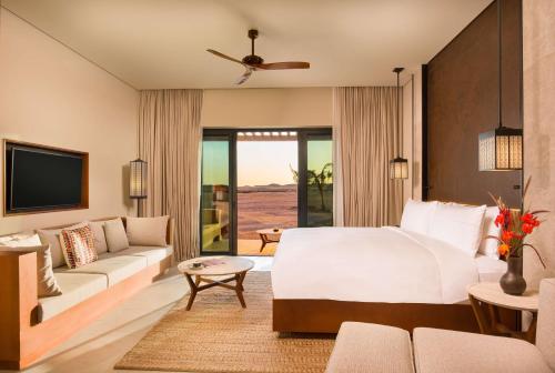 a hotel room with a bed and a couch at Alila Hinu Bay Salalah Mirbat in Salalah