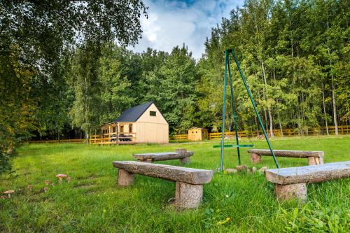 a park with a playground and a small house at Domki na Krzywej Łące in Krajanow