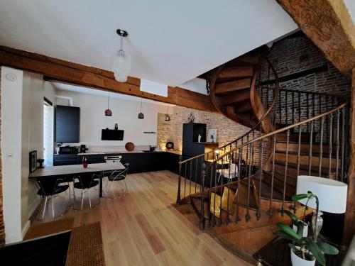 une cuisine et une salle à manger avec un escalier en colimaçon dans un loft dans l'établissement La Loggia - chambres d'hôtes, à Rieux