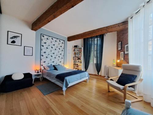 sypialnia z łóżkiem i krzesłem w obiekcie La Loggia - chambres d'hôtes w mieście Rieux