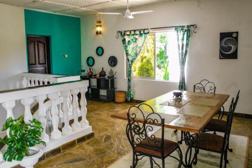a dining room with a table and chairs at Tichi Villas - Diani Beach in Diani Beach
