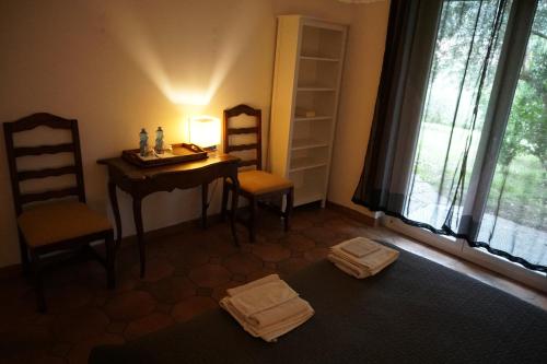 Cette chambre comprend un bureau, 2 chaises et une table. dans l'établissement Golden Hill, à Collina d'Oro