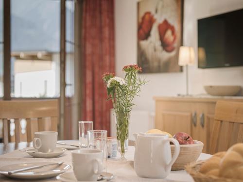 a table with a vase of flowers on top of it at Hotel Garni Larcherhof in Mayrhofen