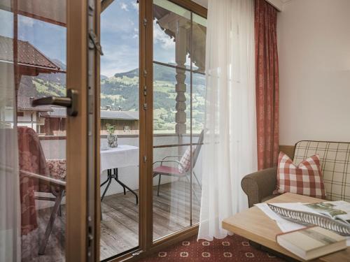 a room with a table and a balcony with a view at Hotel Garni Larcherhof in Mayrhofen