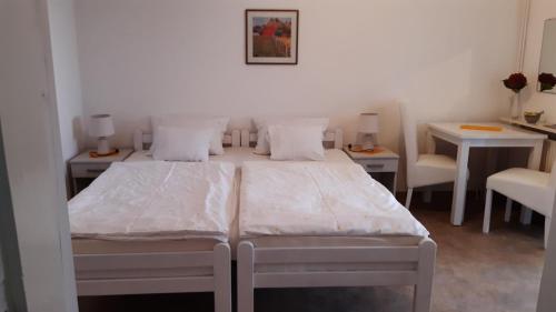 1 Schlafzimmer mit 2 Betten, 2 Tischen und Stühlen in der Unterkunft Apartmani Milosevic in Herceg-Novi
