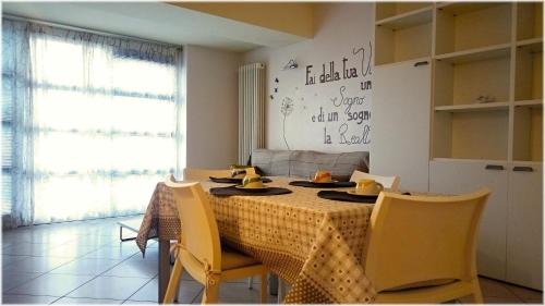 een eetkamer met een tafel en gele stoelen bij LOFT Il "Nido degli Angeli" in Cuneo