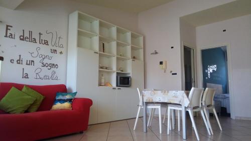 een woonkamer met een tafel en een rode bank bij LOFT Il "Nido degli Angeli" in Cuneo