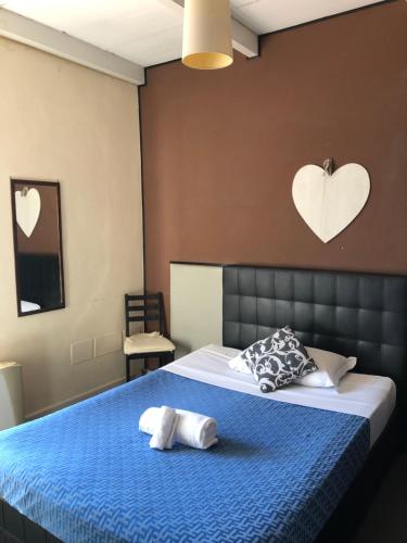 a bedroom with a blue bed with two pillows on it at Hotel Casale dei Massimi in Rome