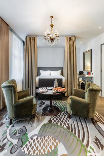a bedroom with a bed and two chairs and a table at The Mandrake in London