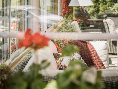 a woman sitting on a couch in front of a window at Hotel Garni Larcherhof in Mayrhofen