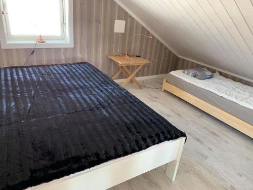 ein Schlafzimmer mit einem Bett und einem Tisch im Dachgeschoss in der Unterkunft Topp moderne familiehytte på Beitostølen (bygget i 2019) in Beitostøl