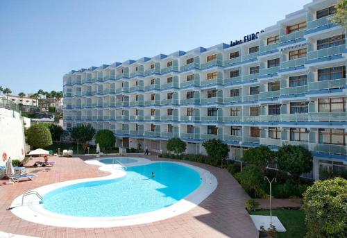 a hotel with a swimming pool in front of a building at Apartamentos Europa in Maspalomas