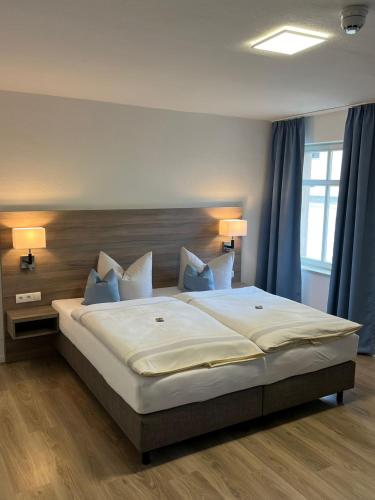 1 dormitorio con 1 cama grande y cortinas azules en Hotel Villa am Paradies, en Jena