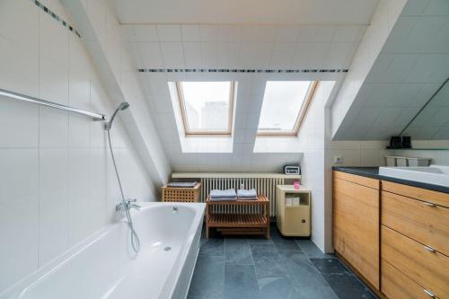 y baño con bañera grande y lavamanos. en Ruhige Dachwohnung mit Terrasse Berlin MITTE - Spacious modern rooftop loft in Berlin MITTE, en Berlín