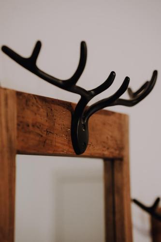 a piece of black metal hanging on a piece of wood at Alpenflair Ferienwohnung 317 Alpengrün in Oberstdorf