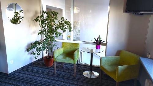 a room with two chairs and a table and plants at Hotel Polonia in Rzeszów