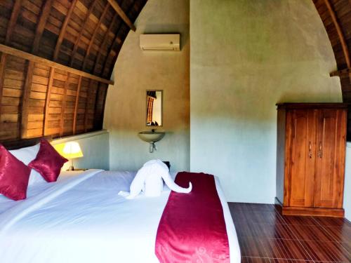 un dormitorio con una cama con un animal de peluche en The Hill Prananta, en Polilit